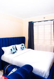 Una cama con dos almohadas azules encima. en Haven studios Naivasha, en Naivasha