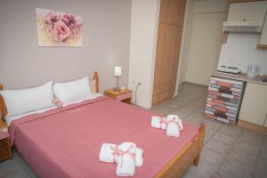 - une chambre avec un lit et des serviettes dans l'établissement Oscar, à Kallithéa Halkidikis