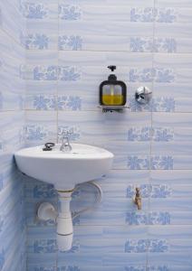 Un baño con lavabo y azulejos azules y blancos. en Haven studios Naivasha, en Naivasha