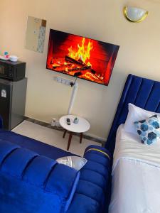 Una sala de estar con un sofá azul y una chimenea. en Haven studios Naivasha, en Naivasha