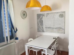 une salle à manger avec une table blanche et des lumières jaunes dans l'établissement Il Giardino segreto Forte dei Marmi, à Forte dei Marmi