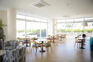 a restaurant with tables and chairs and windows at Kaiah's Haven at Azure North San Fernando Pampanga in San Fernando