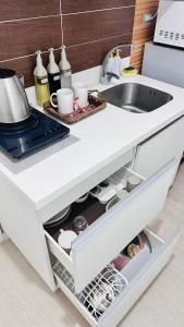 a white kitchen with a sink and a counter at Kaiah's Haven at Azure North San Fernando Pampanga in San Fernando +3 photos