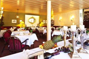 ein Esszimmer mit Tischen und weißen Tischdecken in der Unterkunft Hotel Weingärtner in Bad Wildbad