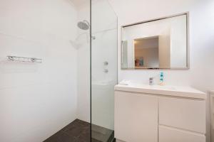 ein weißes Badezimmer mit Waschbecken und Spiegel in der Unterkunft Pelican Cottage in Dunsborough + 13 Fotos