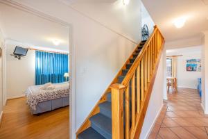 Eine Treppe führt zu einem Schlafzimmer mit einem Bett. in der Unterkunft Pelican Cottage in Dunsborough