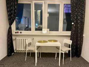stół i krzesła w pokoju z oknem w obiekcie :: Apartment City Center :: w Warszawie +22 zdjęcia