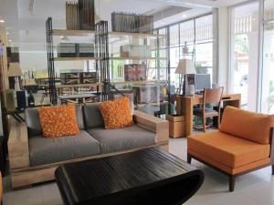a living room with a couch and a table at Gerard Habitat Hotel in Chiang Mai