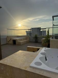 a bath tub on the roof of a building with the sunset at Apto refugio del mar in Cartagena de Indias