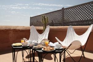 a table with food and chairs on a balcony at Dar El Qadi in Marrakech