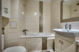 a bathroom with a sink and a tub and a toilet at Apartament Dzień dobry in Wałbrzych +18 photos