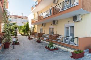 a courtyard of a building with potted plants at Oscar in Kallithea Halkidikis