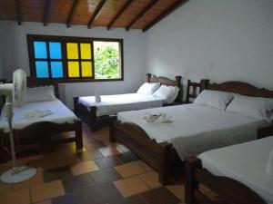 a bedroom with two beds and a window at Hotel Campestre Villa Lucila in San Gil