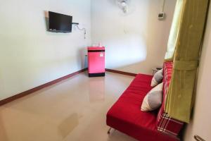 un salon avec un canapé rouge et une télévision dans l'établissement Panita Resort, à Ban Phang Phrao
