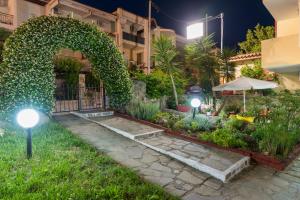 un jardín con arco y luces frente a un edificio en Oscar, en Kallithea Halkidikis