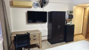 a room with a desk and a tv and a desk sidx sidx sidx at S- ONE HOTEL PATTAYA in Pattaya