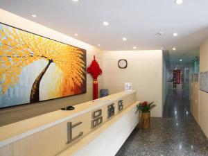 a lobby with a large painting on the wall at Shang Pin Hotel Shenzhen Futian Exhibition Branch in Shenzhen