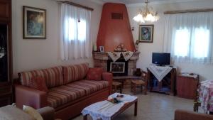 een woonkamer met een bank en een open haard bij Flamiatos Garden Cottages in Pouláta
