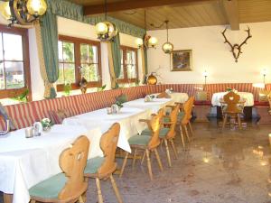 een eetkamer met witte tafels en stoelen bij GarniHotel - Arberblick in Lohberg