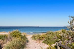 a path to the beach with the ocean in the background at Beachstay Hideaway Vincentia by Book Jervis Bay in Vincentia