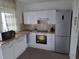 a kitchen with white cabinets and a white refrigerator at mily appart 68 in Rixheim