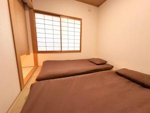 a bedroom with two beds and a window at 東福寺2 都憶 in Kyoto