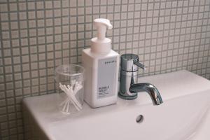 a bathroom sink with a bottle of soap and a cup at 洋Casa in Hengchun South Gate