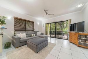 un soggiorno con divano e TV a schermo piatto di Near Beach 2 BR unit The Strand a North Ward