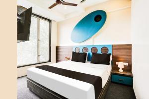 a bedroom with a large bed and a tv at Hotel O Shubham Suites in Dive