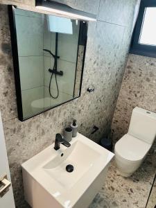 a bathroom with a white sink and a toilet at Kallisti 1bd Central Stay - Wow View in Nicosia +12 photos