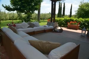 a living room with white couches on a patio at Villa Ines with pool and Jacuzzi hot tube in Terranuova Bracciolini