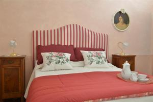 a bedroom with a bed with a red blanket and two tables at Villa Ines with pool and Jacuzzi hot tube in Terranuova Bracciolini +38 photos