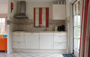 una cucina con armadi bianchi e dettagli rossi di Buitengoed Het Lageveld - 65 a Hoge-Hexel