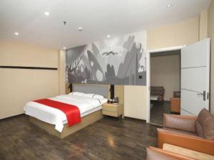 a bedroom with a large bed and a couch at Thank Inn Hotel He'nan Xinxiang Changyuan Bo'ai Road in Changyuan