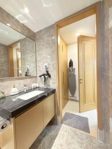 a bathroom with a sink and a large mirror at R&F Seine Region at ANJU in Johor Bahru