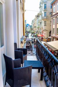 uma varanda com cadeiras e mesas e vista para uma rua em Apart-hotel Horowitz em Lviv