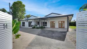 a white house with a driveway in front of it at Villa Ibis Family Home with Pool in Kewarra Beach in Kewarra Beach