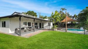 a white house with a pool and a yard at Villa Ibis Family Home with Pool in Kewarra Beach in Kewarra Beach