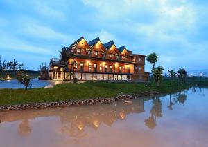 a large house sitting on top of a river at Artisan Hostel in Toucheng