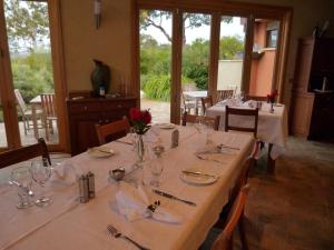 a dining room with a long table with wine glasses at Meringa Springs in Halls Gap