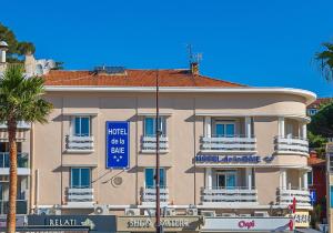 un edificio con una señal azul delante de él en Hotel de la Baie, en Bandol