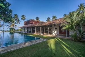 a house with a swimming pool next to a building at The Frangipani Tree by Edwards Collection - Thalpe in Unawatuna