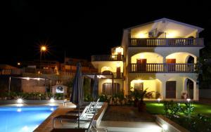 eine Villa mit einem Pool in der Nacht in der Unterkunft Apartments Bago in Trogir