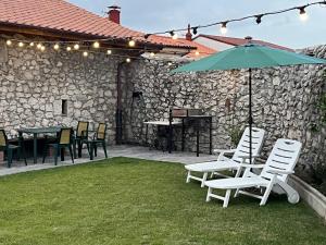 a patio with a table and chairs and an umbrella at Apartamentos ROSAMUNDA SANTANDER in Santander