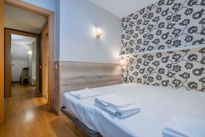 ein Schlafzimmer mit einem weißen Bett und einer schwarz-weißen Wand in der Unterkunft Bright and modern Duplex with terrace in Eixample district P2 in Barcelona