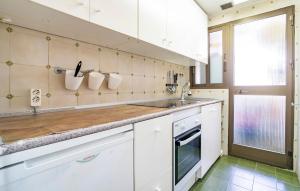 a kitchen with white cabinets and a sink at Gorgeous Apartment In Fuengirola in Fuengirola