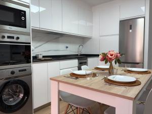a kitchen with a table with plates and flowers on it at Apartamento Cabo de Ajo in Ajo