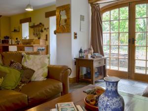una sala de estar con un sofá y una mesa en Hen Dy Goits, en Llangadwaladr