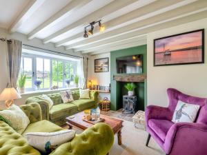 a living room with green and purple furniture at Seascape Cottage in South Creake