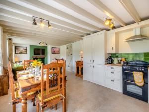 a kitchen and dining room with a table and a stove at Seascape Cottage in South Creake